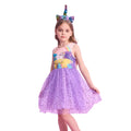 Young girl wearing a purple unicorn-themed dress and headband on a white background