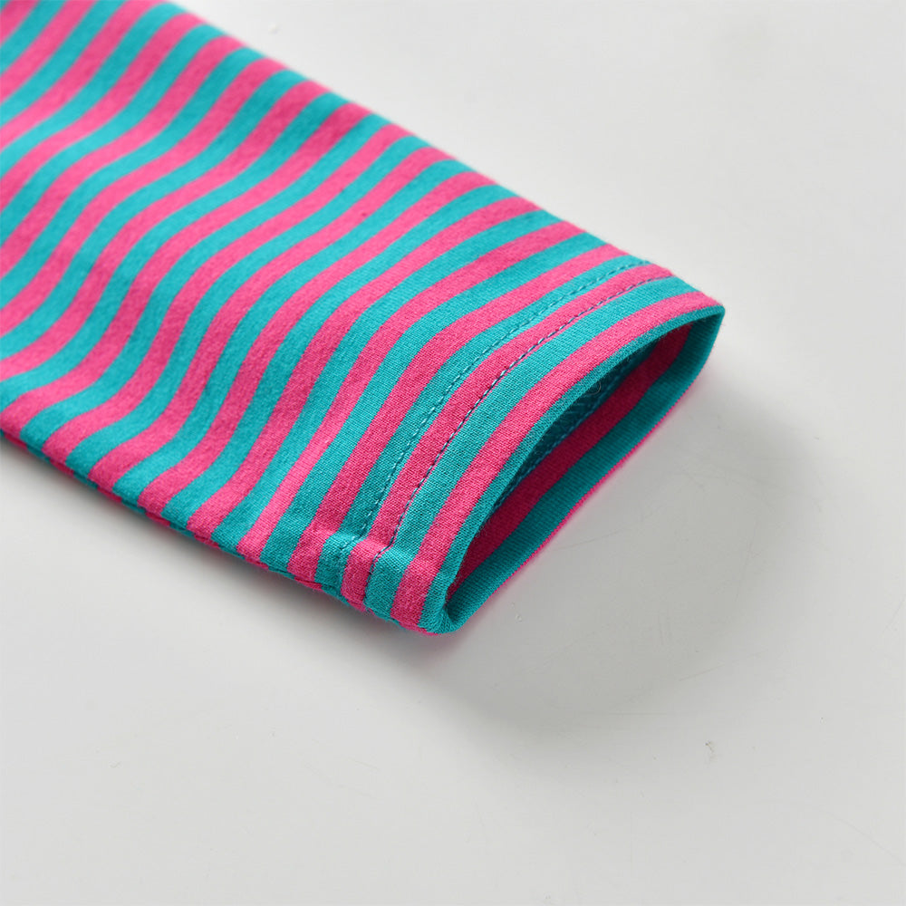 Roll of fabric with pink and teal stripes on a light gray background