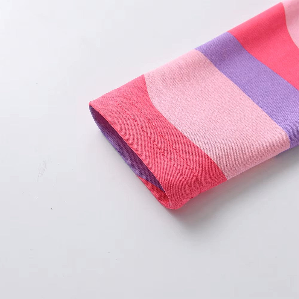 Close-up of a folded fabric with pink and purple stripes on a light gray background