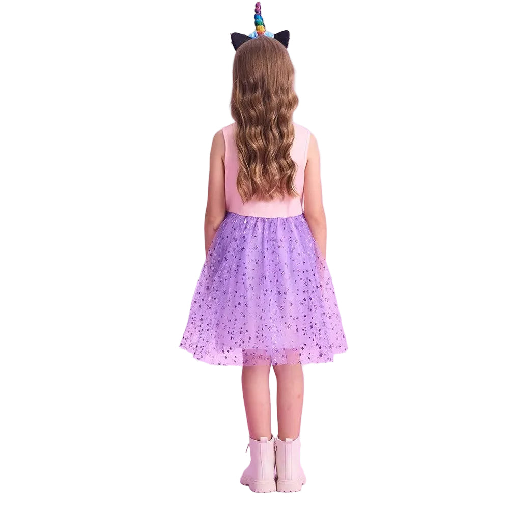Child wearing a pink dress with a purple skirt and unicorn horn and ears on a white background