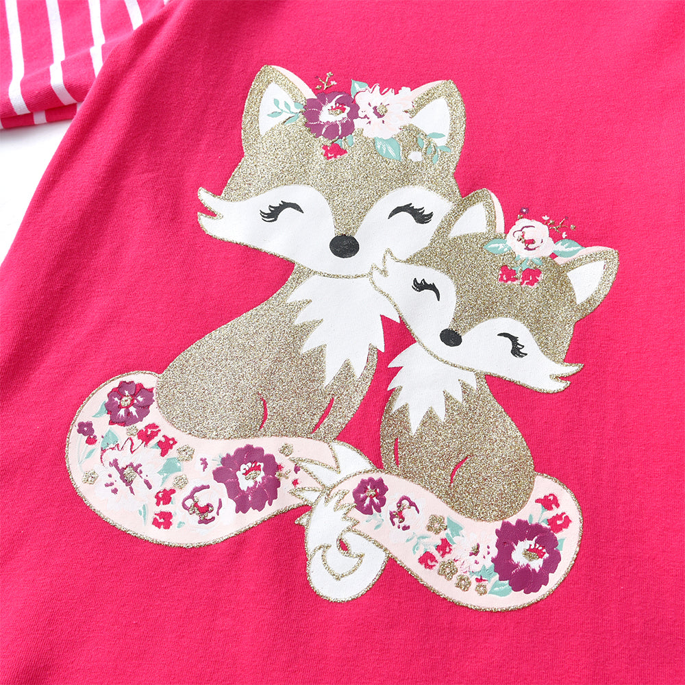 Two glittery foxes with floral designs on a pink background