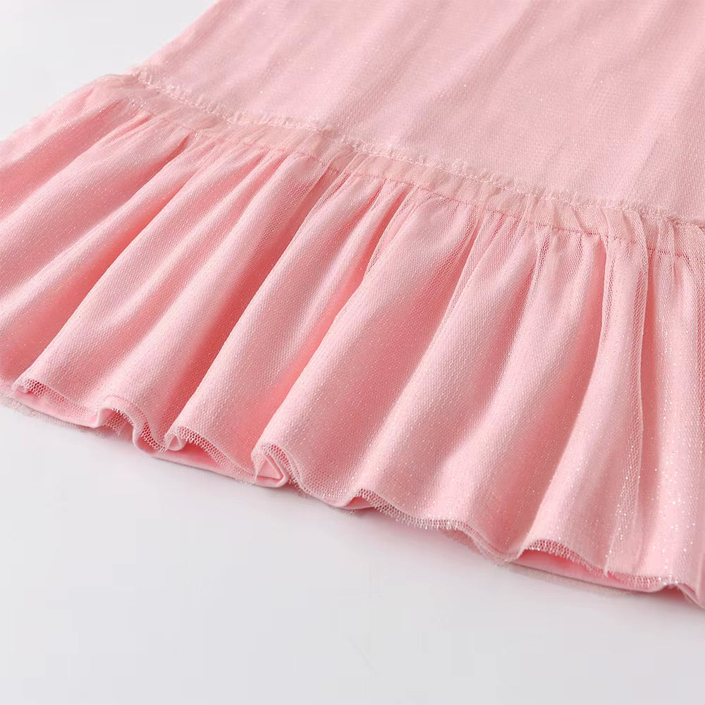 Close-up of a pink skirt with ruffled hem on a light gray background
