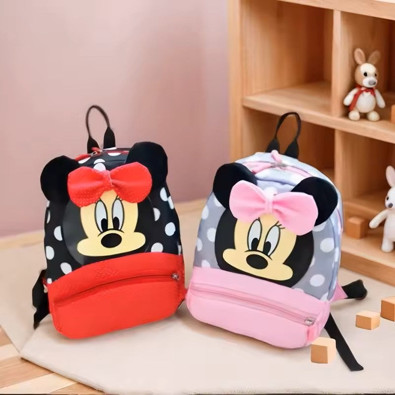 Two children's backpacks with cartoon character designs on a wooden floor.
