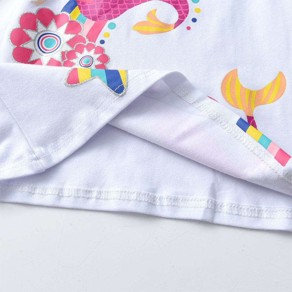 Close-up of a white fabric with colorful floral and lollipop designs on a light gray background