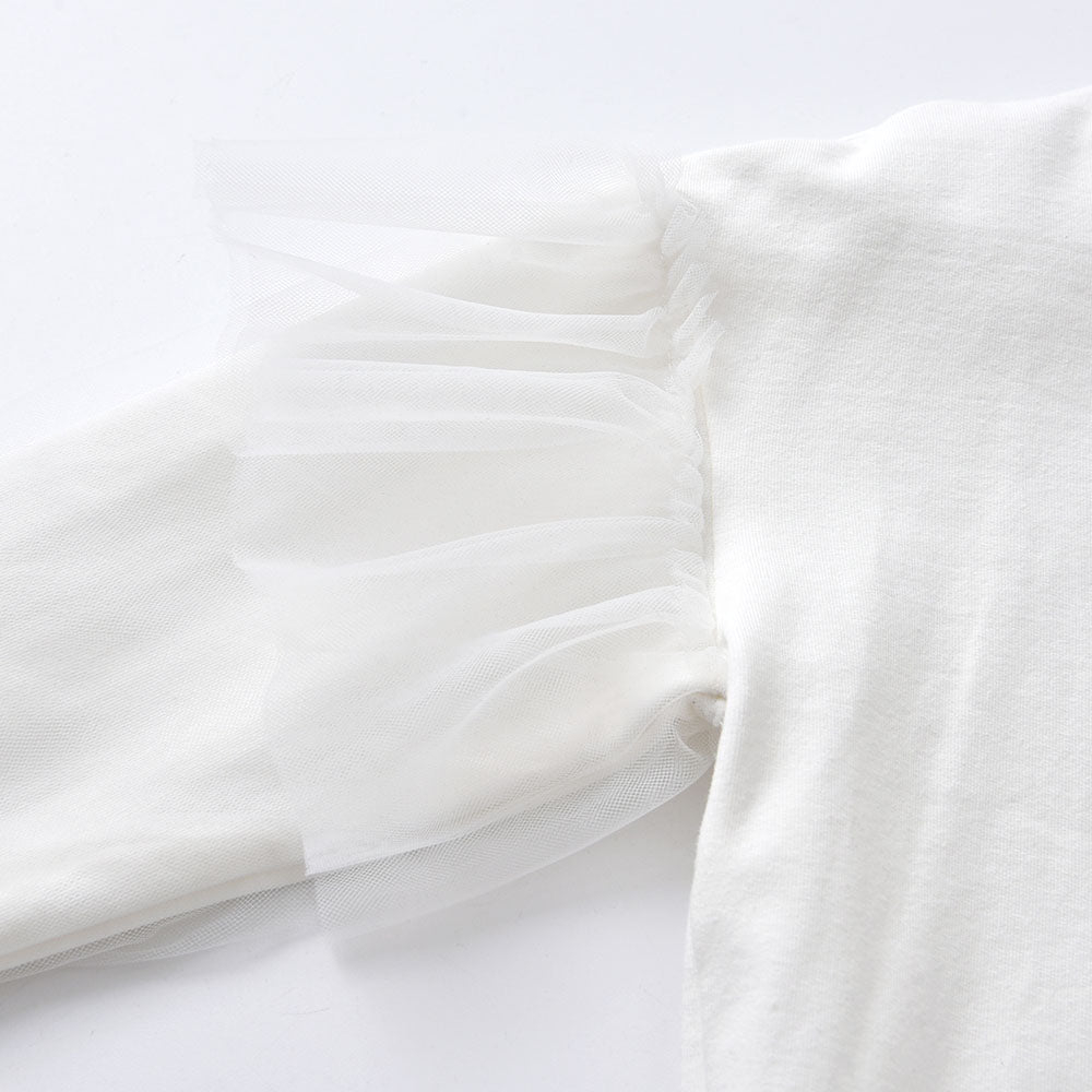 Close-up of white fabric with a subtle pattern on a light gray background