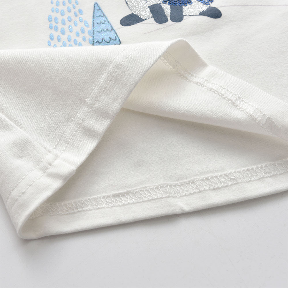 Close-up of a white fabric with embroidered blue and gray design on a light gray background