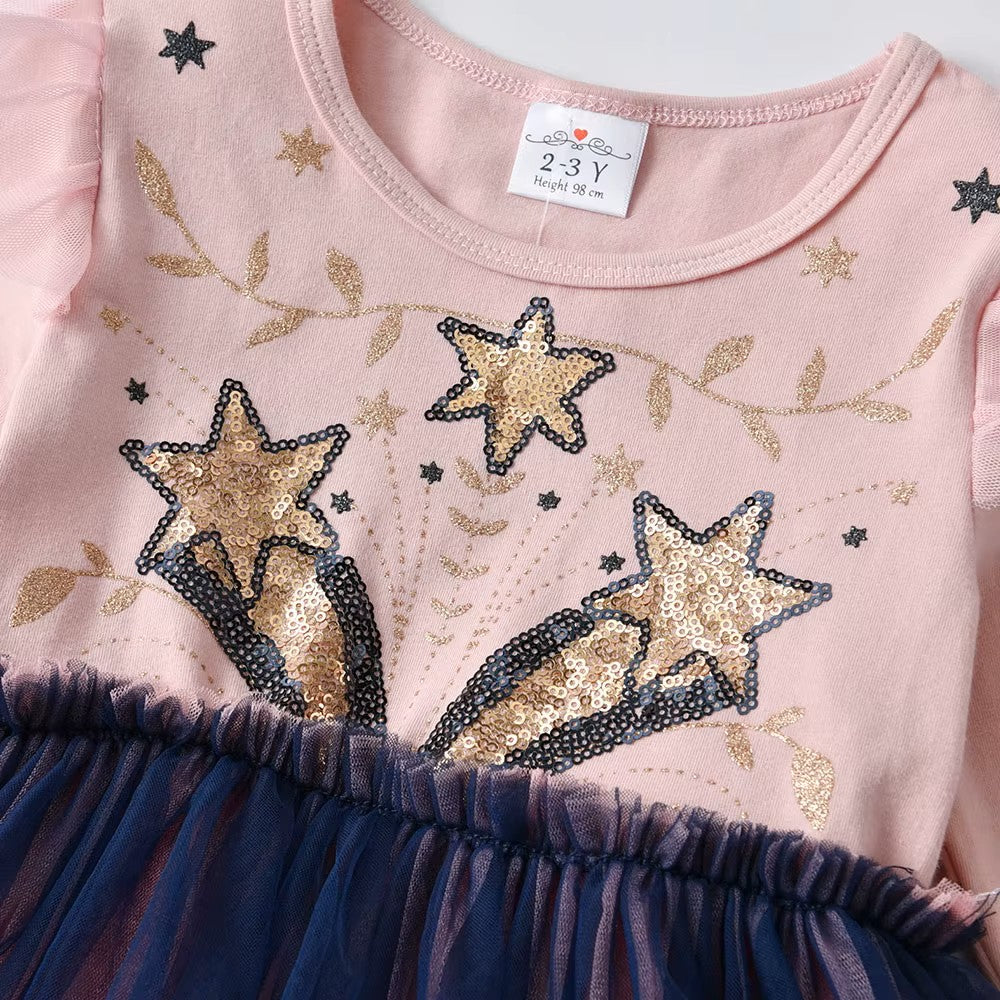 Pink dress with star designs and a blue skirt, close-up view.
