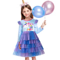 Young girl in a colorful unicorn-themed dress holding balloons on a white background