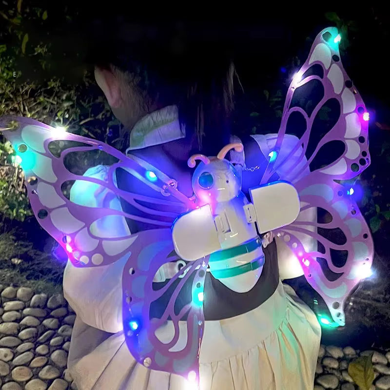Person wearing butterfly wings with LED lights in a dark outdoor setting