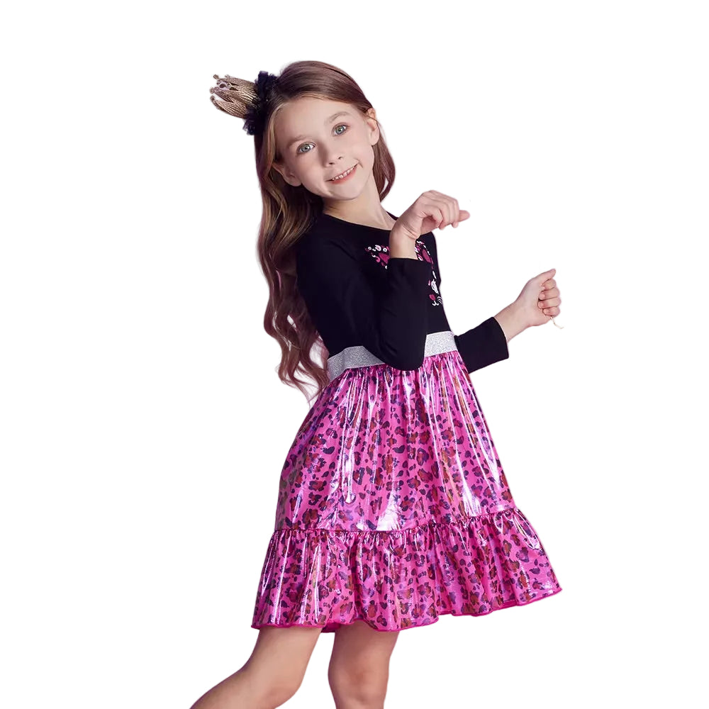 Young girl wearing a black top with floral details and a pink leopard print skirt on a white background