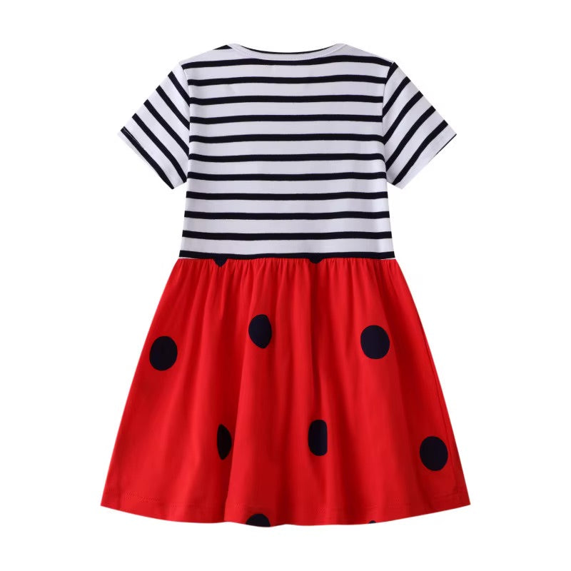 Dress with striped top and red skirt with black polka dots on a white background
