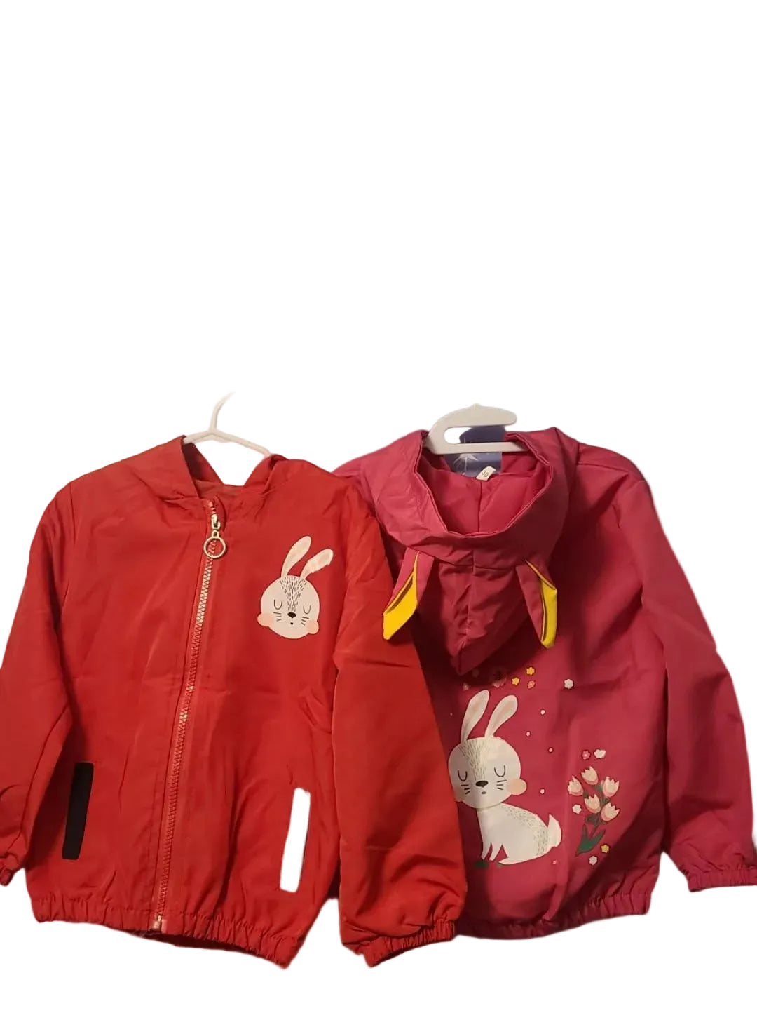 Two red children's jackets with bunny designs on a white background