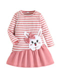 Pink and white striped dress with a cartoon bunny design on a textured surface.