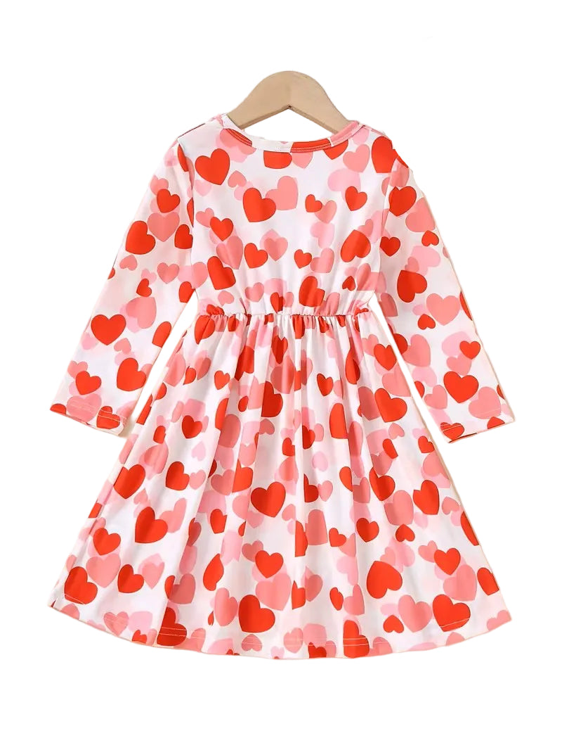 Children's dress with red and pink heart pattern on a white background