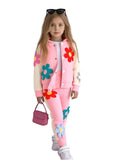 Child wearing a pink outfit with floral designs on a white background