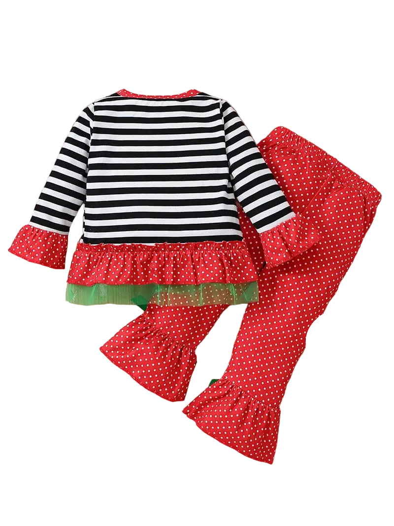 Children's outfit with striped top and red polka dot pants on a wooden surface.