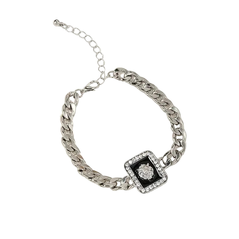 Silver chain bracelet with a square pendant featuring a black center and clear stones on a beige background