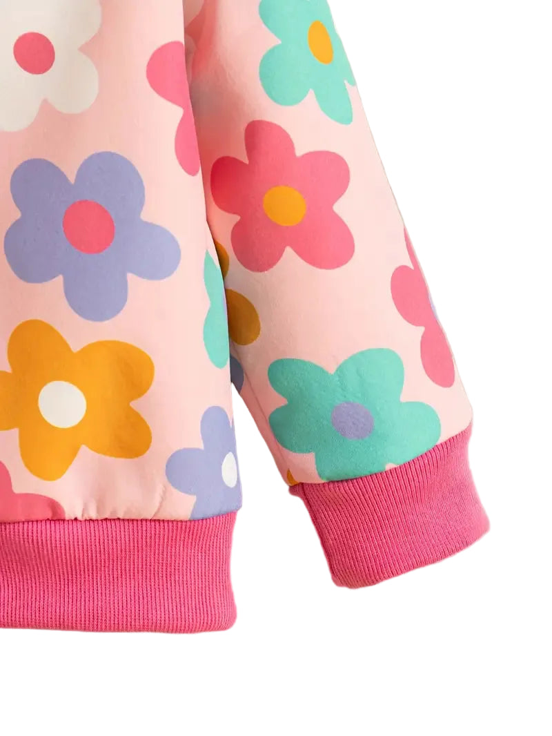 Close-up of a pink fabric with colorful flower patterns on a light gray background