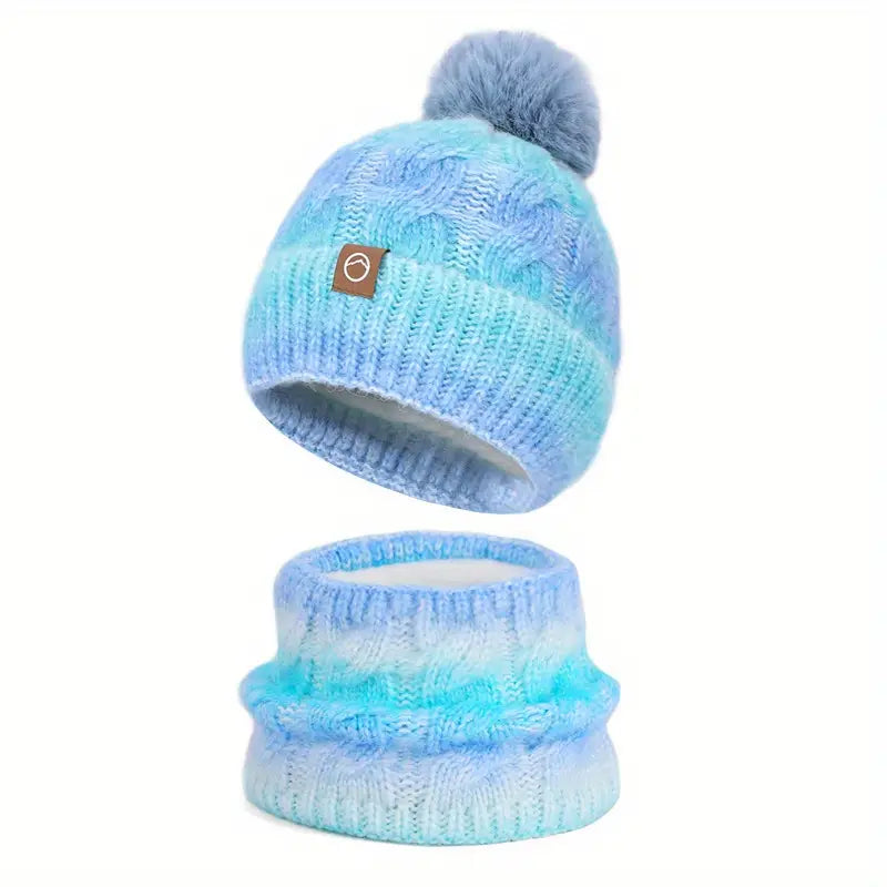 Blue knit beanie with pom-pom and matching scarf on a white background