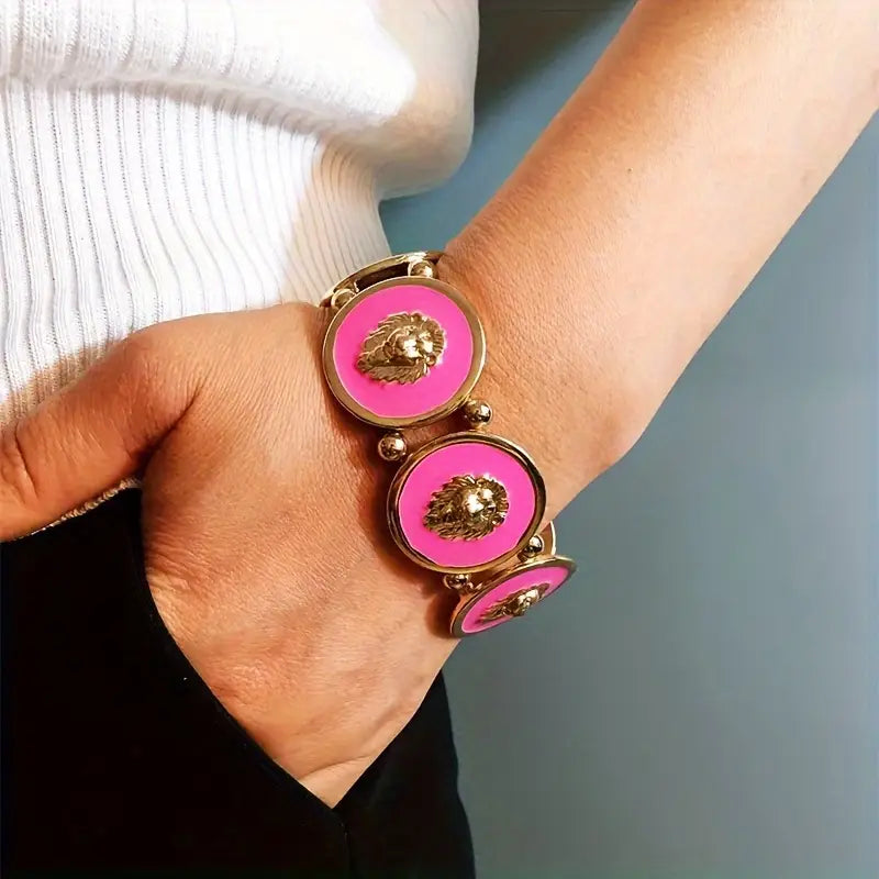 Bracelet with pink circular charms and gold accents on a wrist against a neutral background