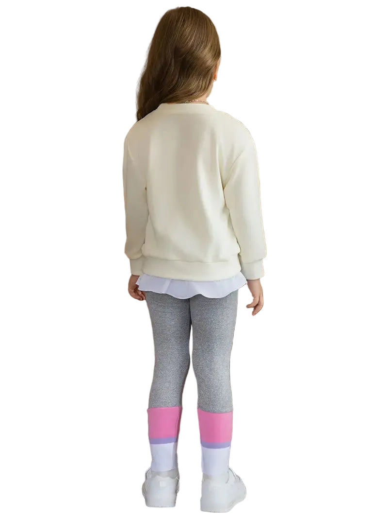 Child wearing a cream sweatshirt, gray leggings with pink accents, and white shoes on a white background