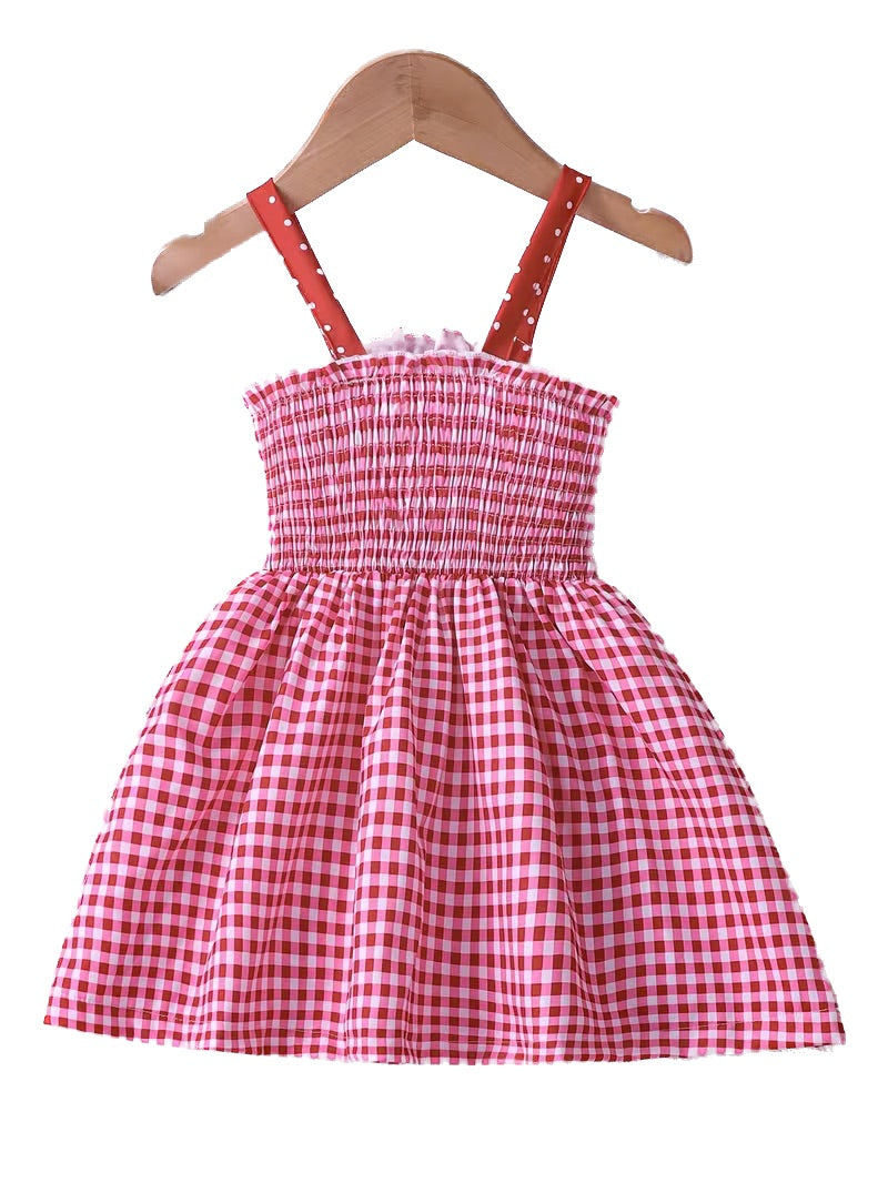 Red and white checkered dress with suspenders on a hanger against a white background