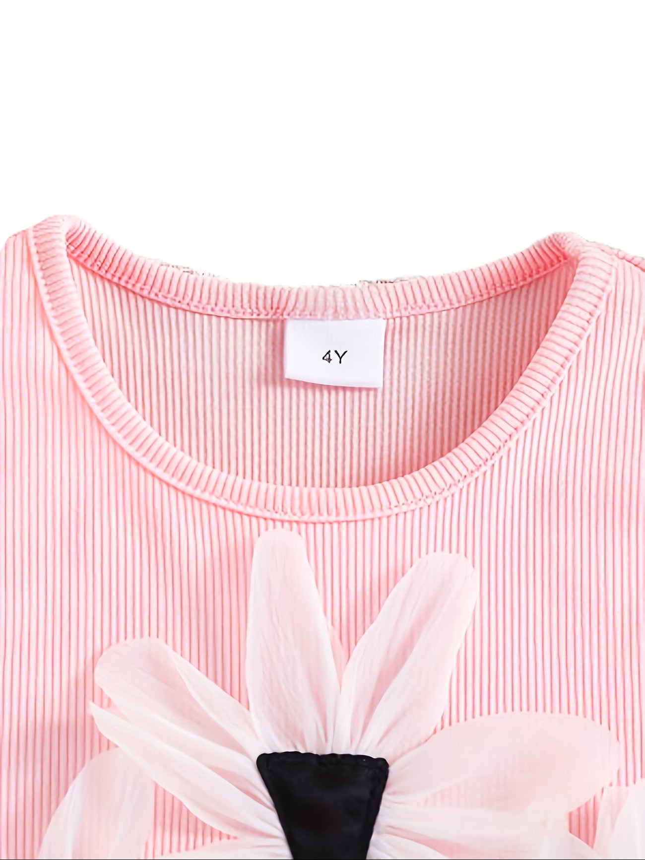 Close-up of a pink dress with floral details and a size tag on a white background