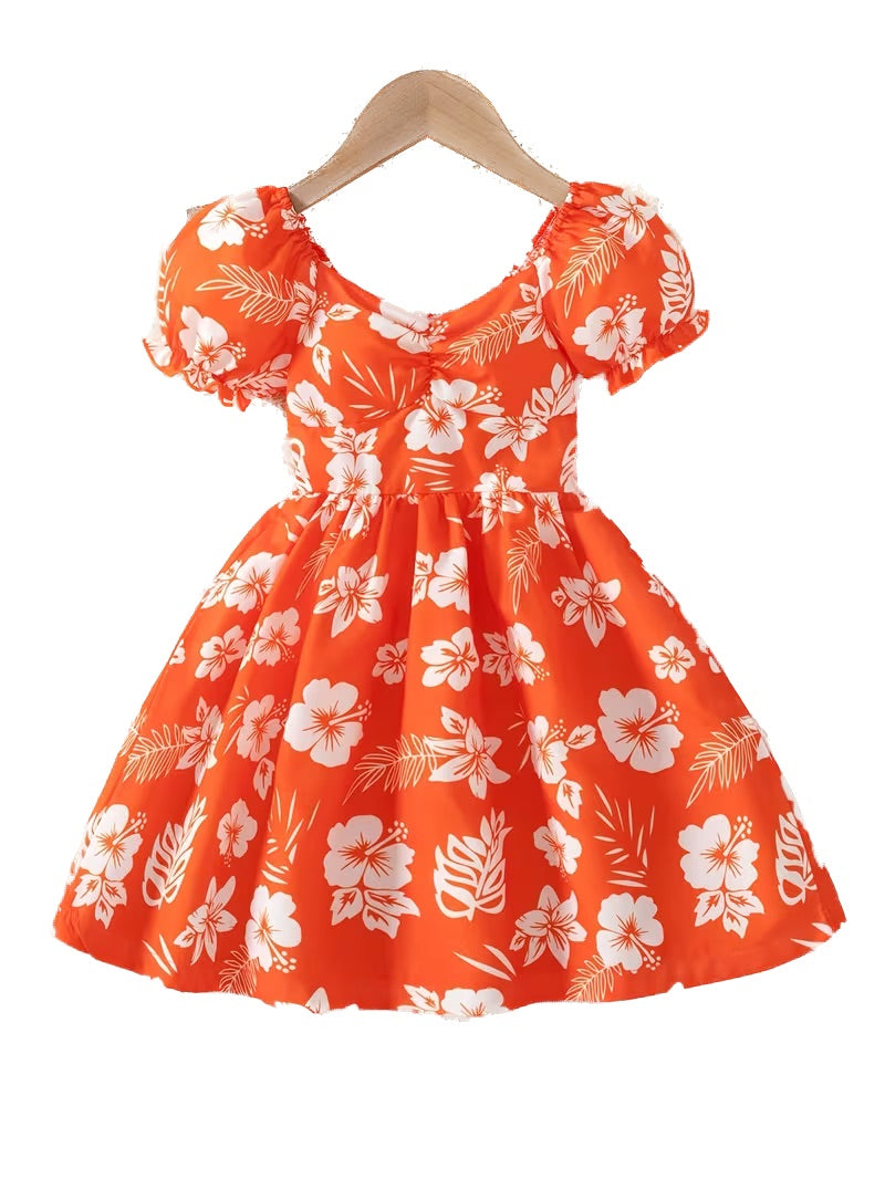 Orange dress with white floral pattern on a hanger against a white background