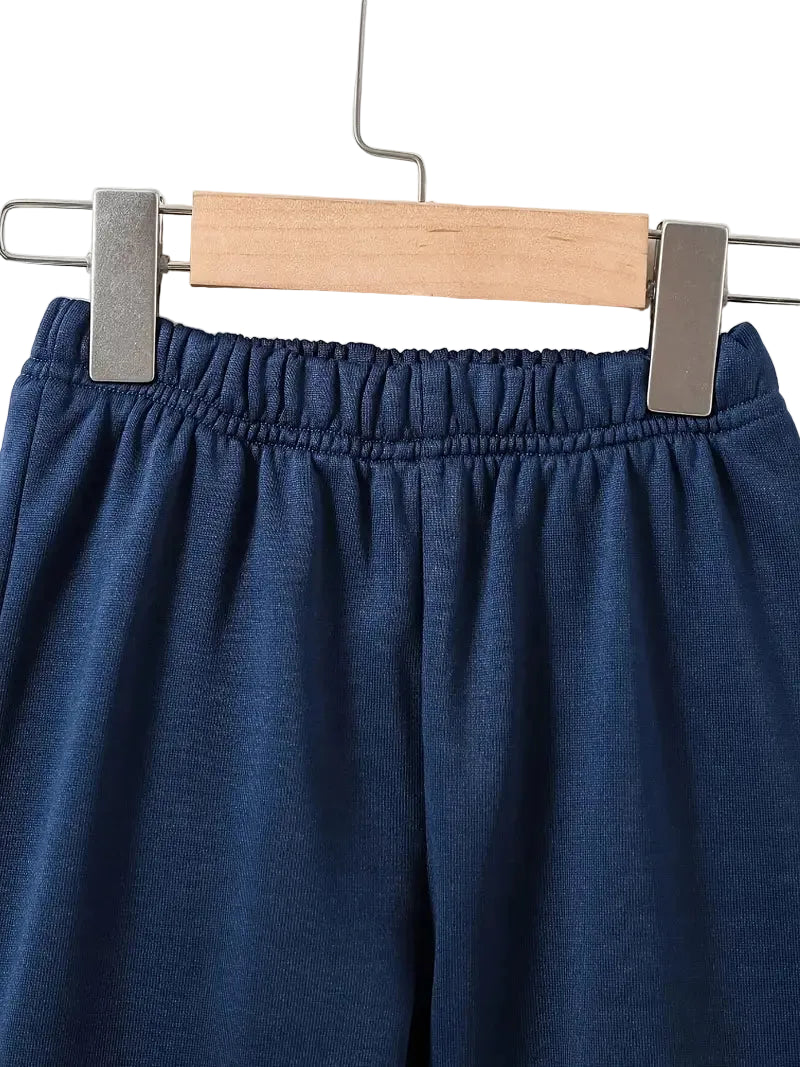 Blue pants on a wooden hanger against a white background