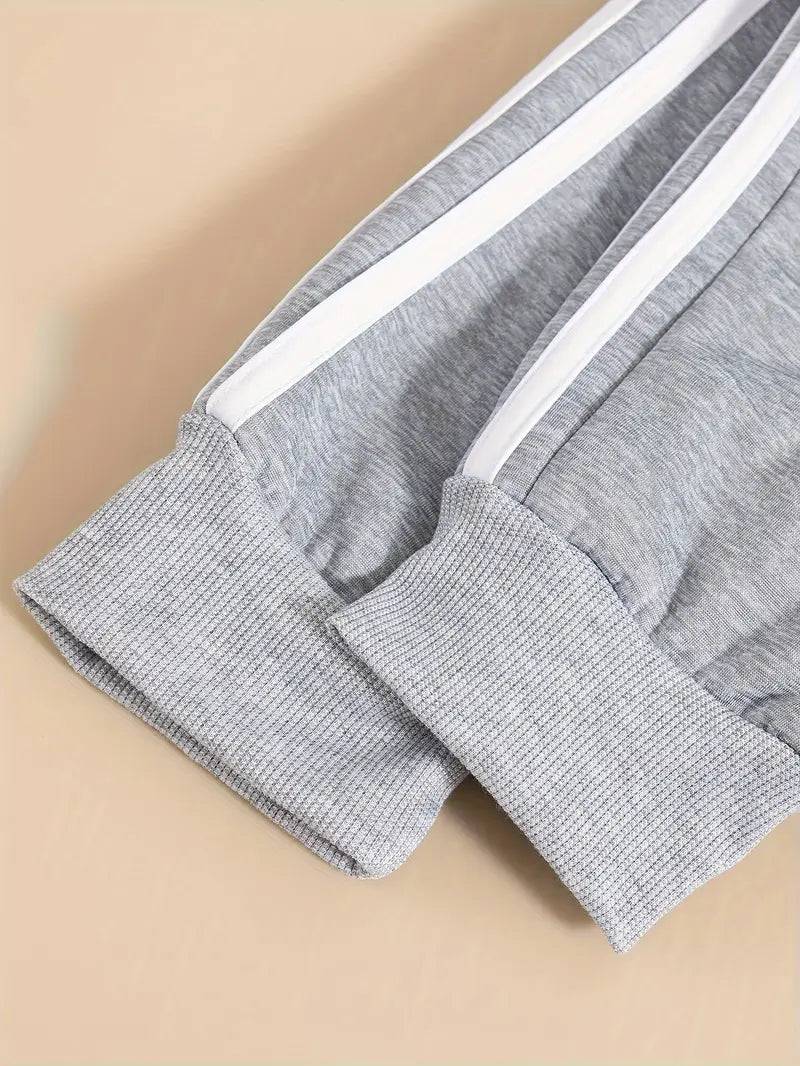 Gray sweatpants with white stripes on a beige background