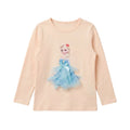 A children's long-sleeve t-shirt in a pale peach color, featuring a graphic of the Disney character Elsa in a light blue tulle dress with a blue bow on the front.