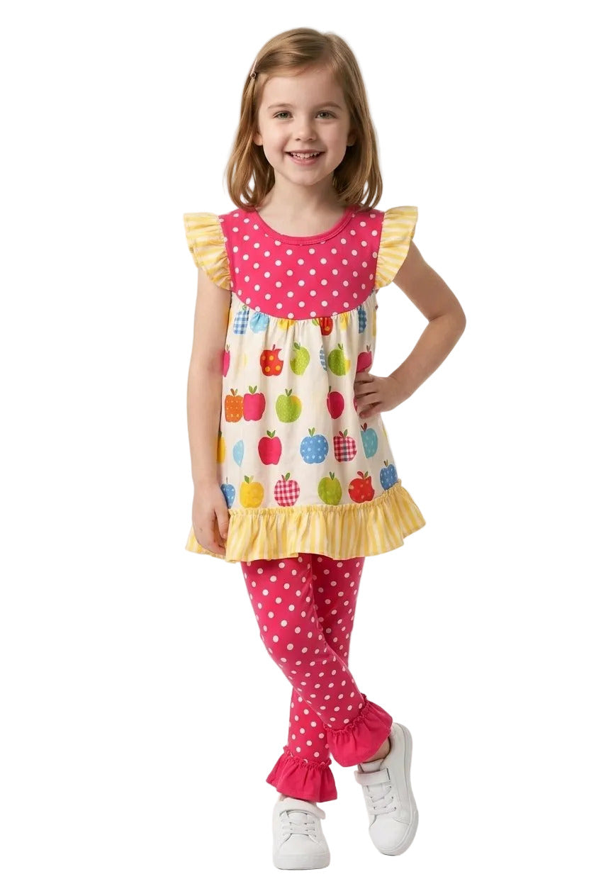 Young girl wearing a colorful outfit with polka dots and apple design on a white background