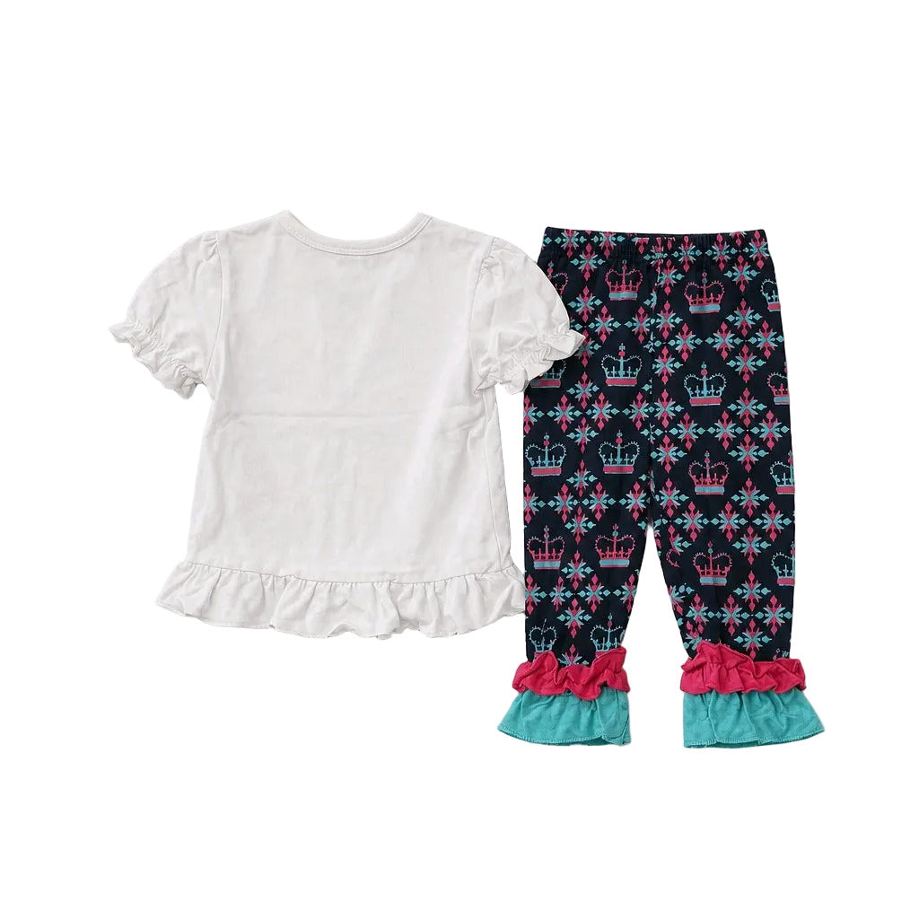 A two-piece toddler girl's outfit set featuring a white short-sleeve ruffle-trim top and navy blue patterned leggings with pink and teal ruffle hems.