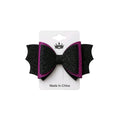 Black and pink glitter bow on a white card with a brand logo, on a light gray background.