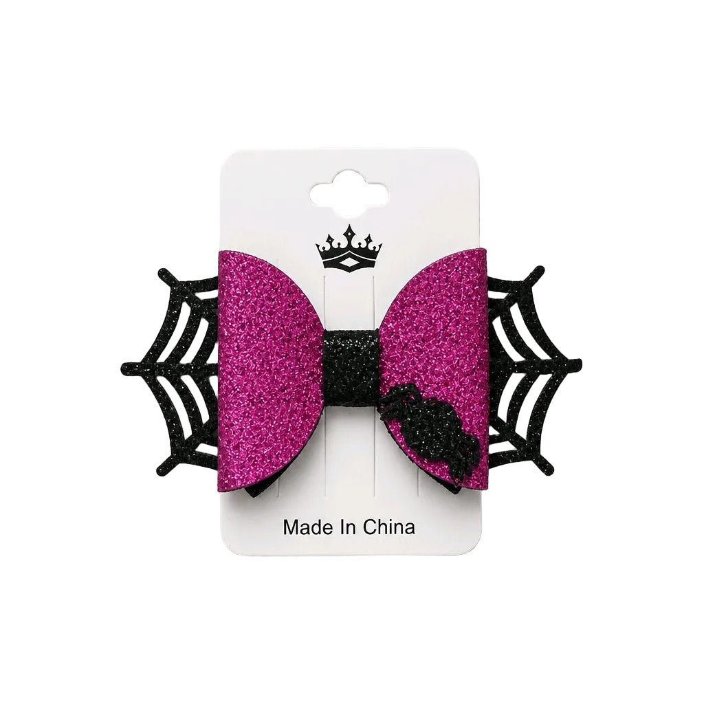 Pink glitter bow with black spider web design on a white card, 'Made in China' text visible