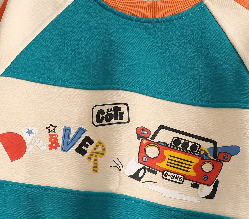 Close-up of a children's raglan sweatshirt featuring a cream body, teal blue upper and lower sections, and a colorful graphic print of a red jeep and the word 'Côtr' on the chest.