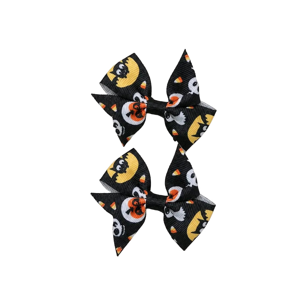 Two Halloween-themed hair bows with pumpkins and ghosts on a light gray background