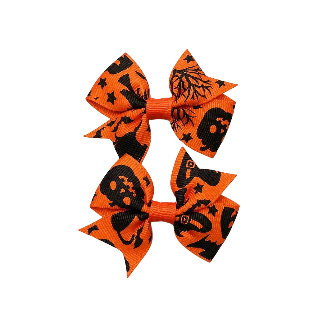 Three orange hair bows with black Halloween patterns on a light gray background