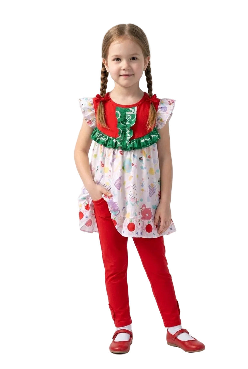 Young girl wearing a colorful dress with a red apron and red pants on a white background