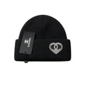 Black beanie with heart design and Chanel tag on a white background