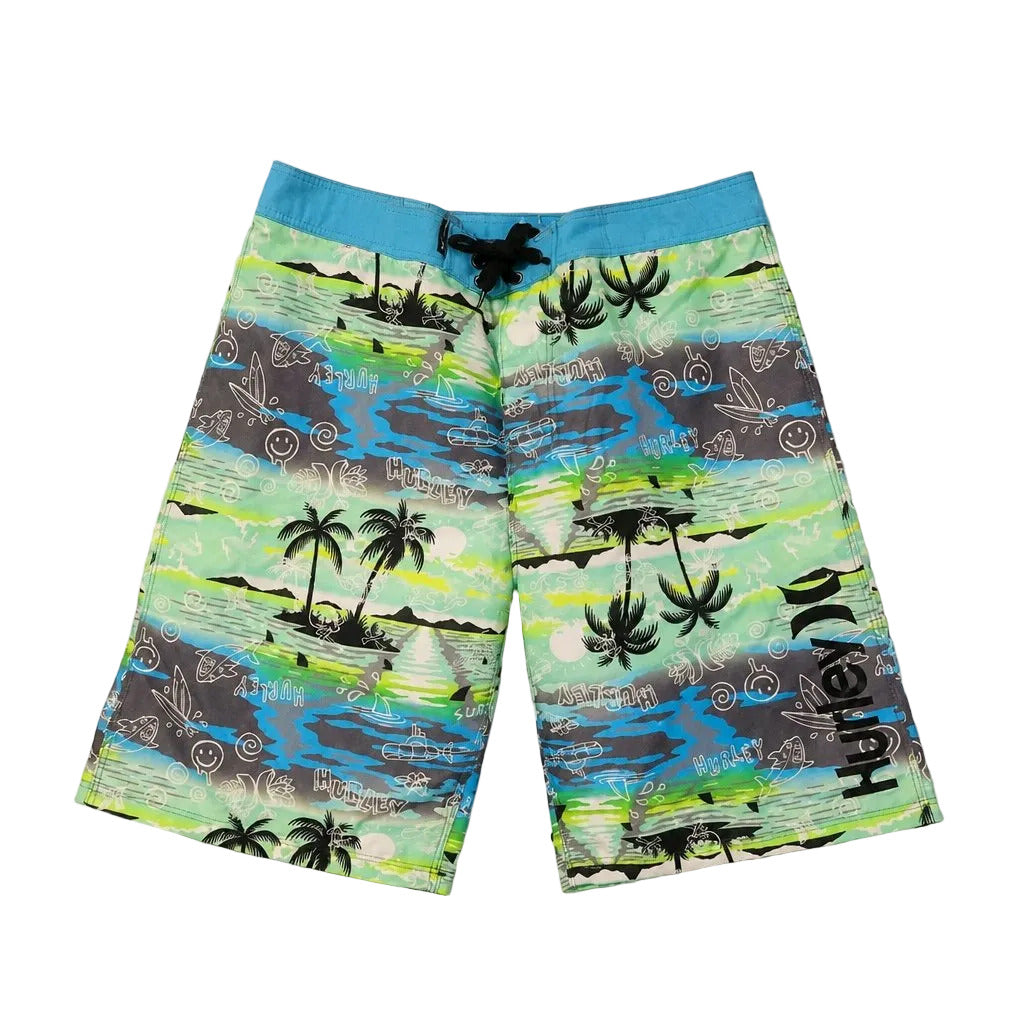 Colorful beach shorts with tropical island design on a gray background