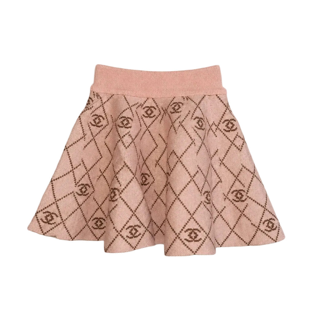 A pink knit flared skirt with a dark brown argyle pattern featuring interlocking CC logos, laid flat on a light gray background.