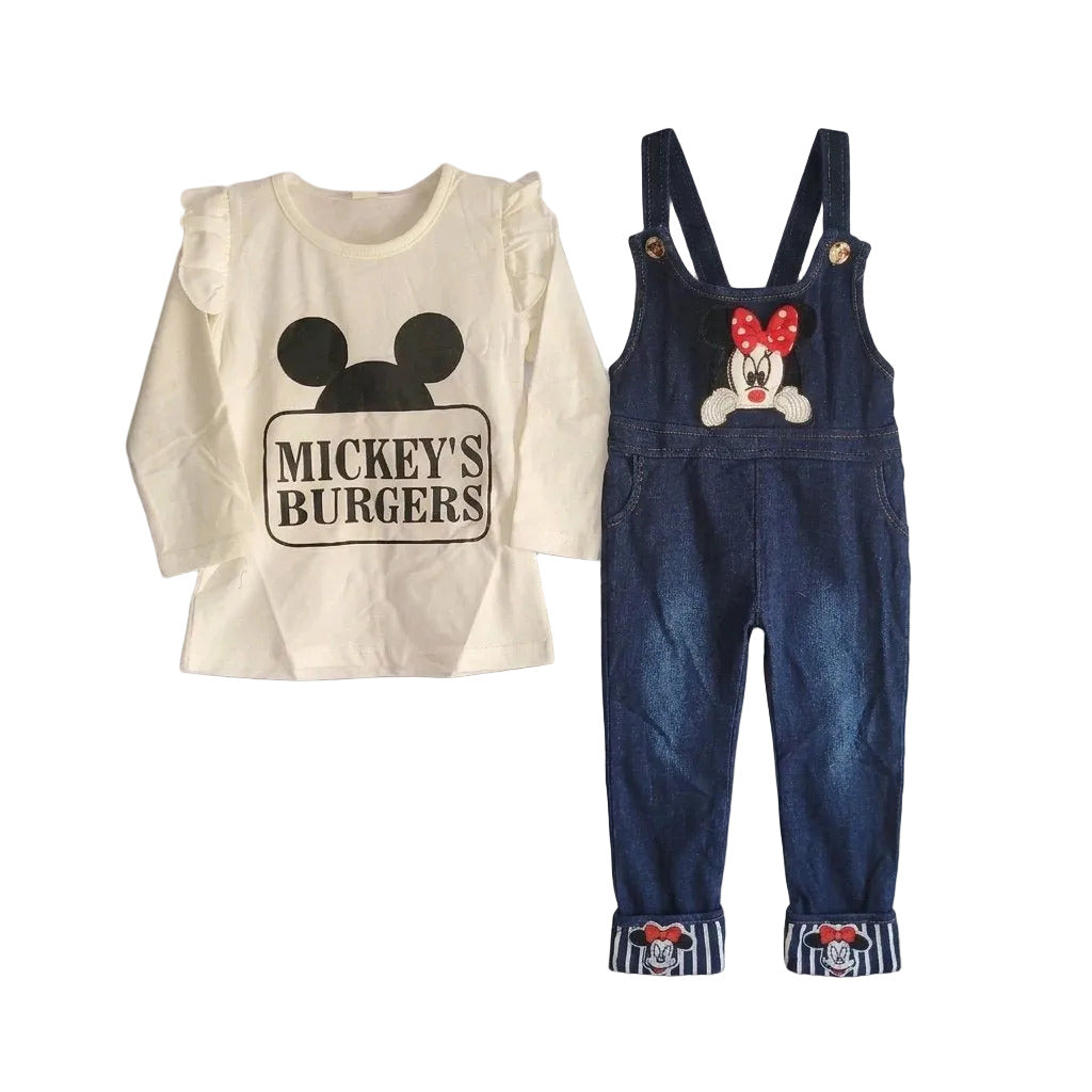 A toddler girl's two-piece Disney Mickey themed outfit set, featuring a cream long-sleeve top with a black Mickey Mouse head and 'MICKEY'S BURGERS' graphic, paired with dark blue denim overalls with a Minnie Mouse graphic on the chest and striped cuffs.