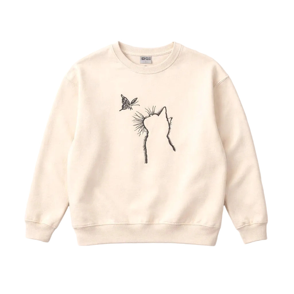 Beige sweatshirt with a black cat and butterfly design on a light gray background