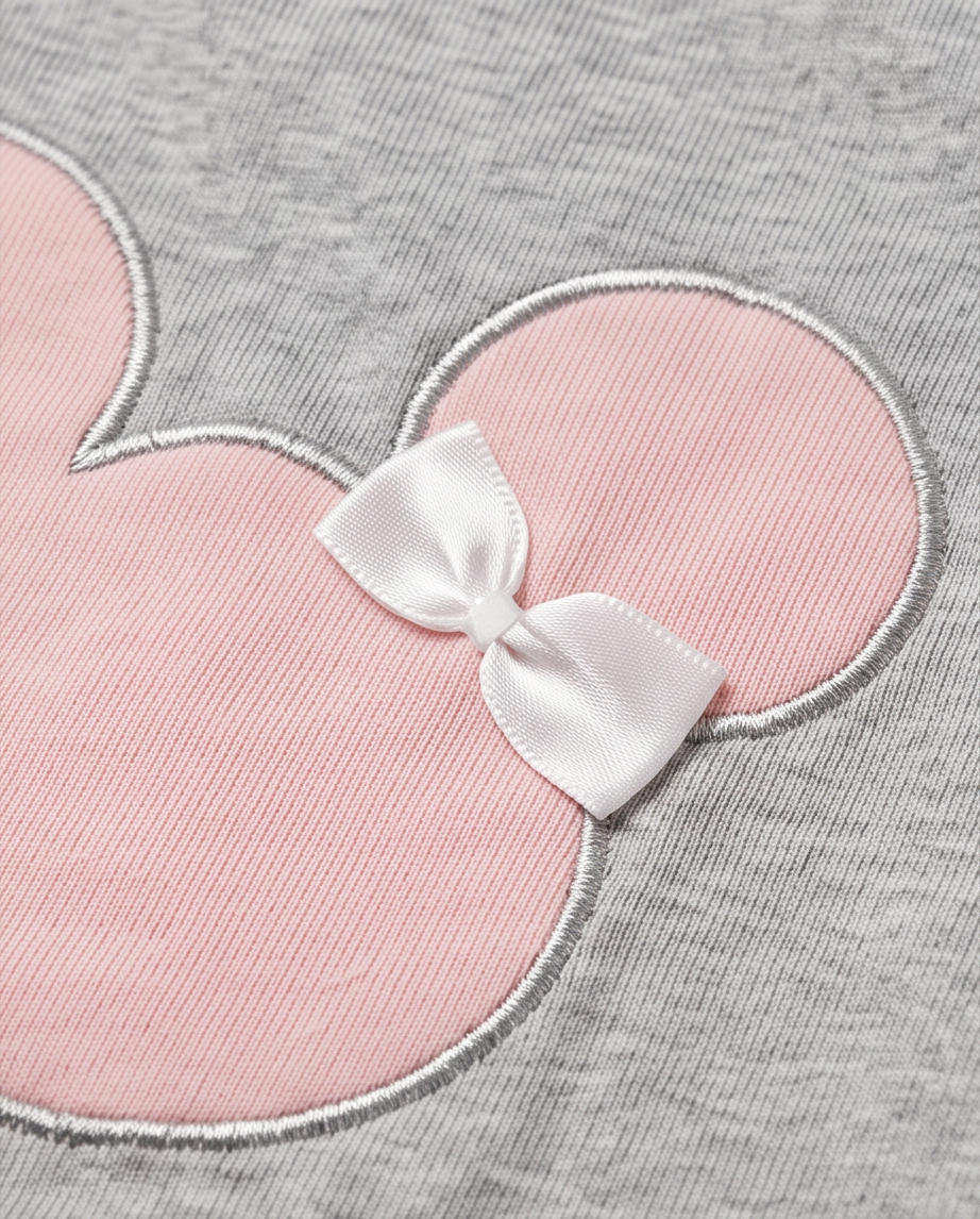 Close-up of a gray knit garment featuring a large pink Minnie Mouse-style head patch with a white satin bow at the center.