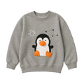 A heather gray crewneck sweatshirt featuring a 3D penguin applique with an orange beak and feet, a white outline of a crown, and black star details on the front.