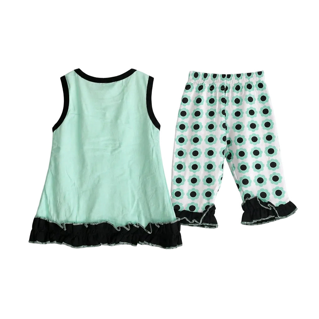 A two-piece toddler girl's outfit set featuring a mint green sleeveless top with black trim and a black ruffled hem, paired with matching mint green pants with a black polka dot pattern and black ruffled cuffs.