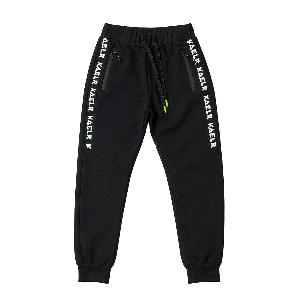 Black sweatpants with white 'KAER KAEIR' text printed down both sides of the legs, featuring a drawstring waist and zippered side pockets, shown flat on a light gray background.