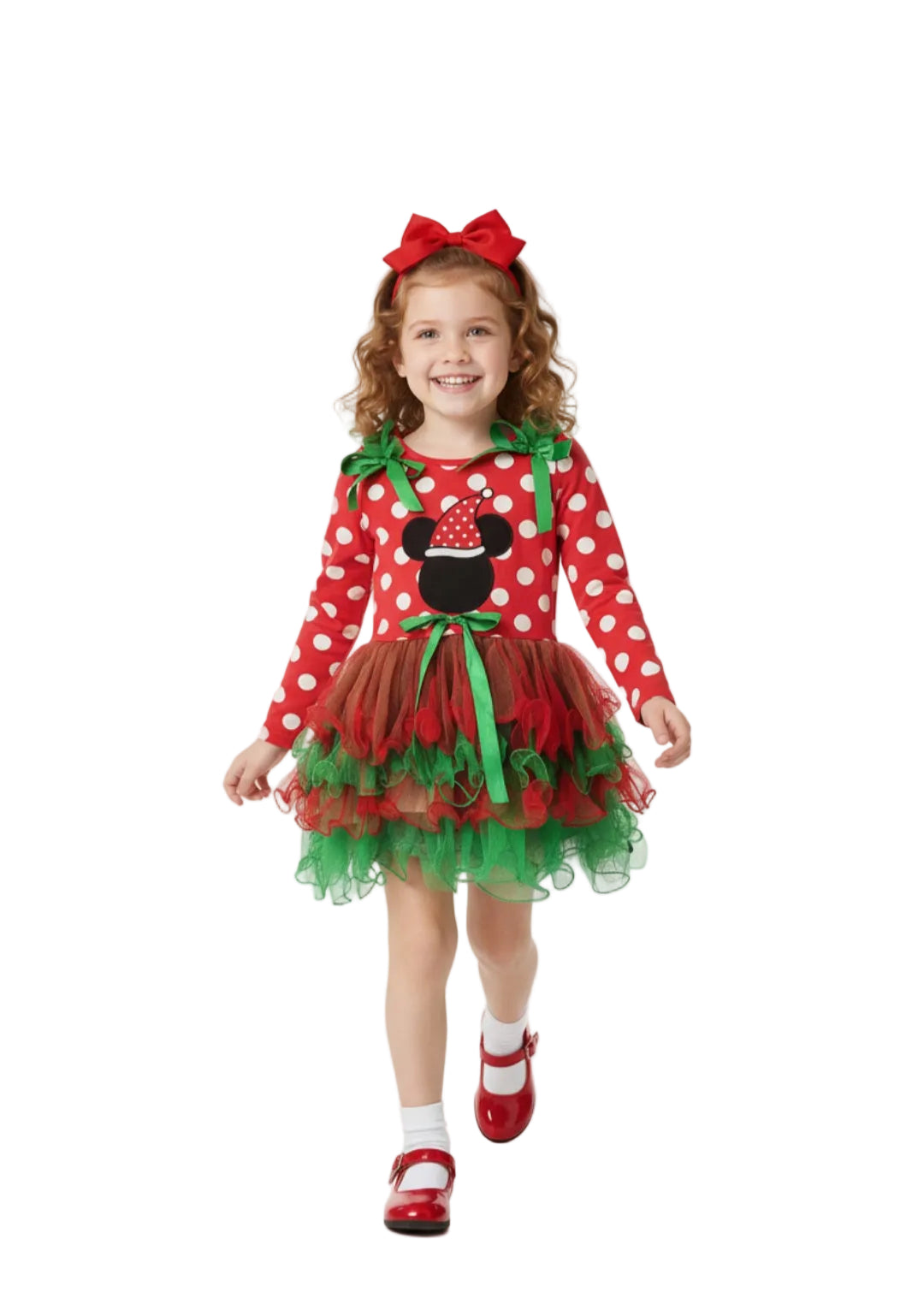 Child wearing a festive red and green dress with a bow, standing against a white background.