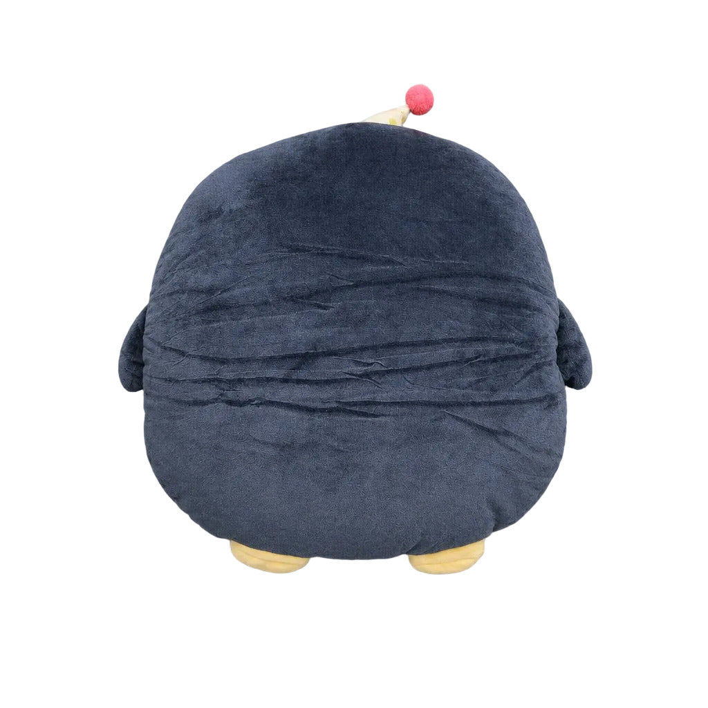 A plush penguin cushion viewed from the back, featuring a dark navy blue body, small yellow feet, and a small red accent on a white tip.